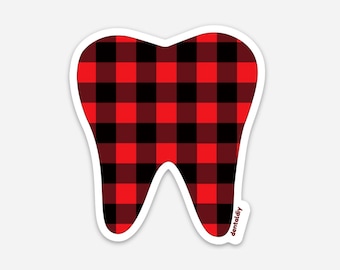 Può includere: Un adesivo a forma di dente con un motivo a quadri rossi e neri. L'adesivo ha un contorno bianco e il testo "dentaldy" nell'angolo in basso a destra.