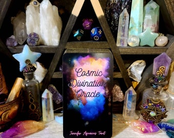 May include: A card from the Cosmic Divination Oracle deck, featuring a colorful nebula background with the text "Cosmic Divination Oracle" and "Jennifer Aquarius Tarot".