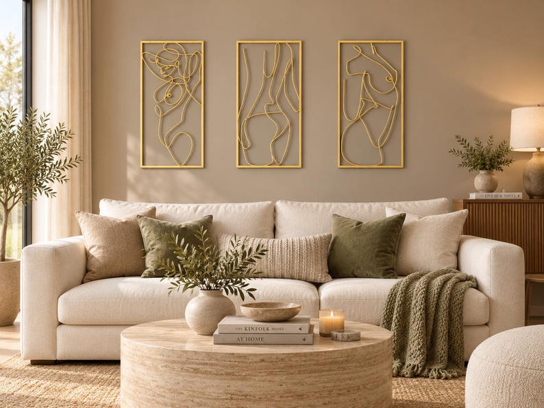 May include: A set of three rectangular wall art pieces featuring gold-toned wire outlines of human figures. Each piece is framed in a thin gold border, showcasing continuous line art designs that depict abstract silhouettes of the human form.