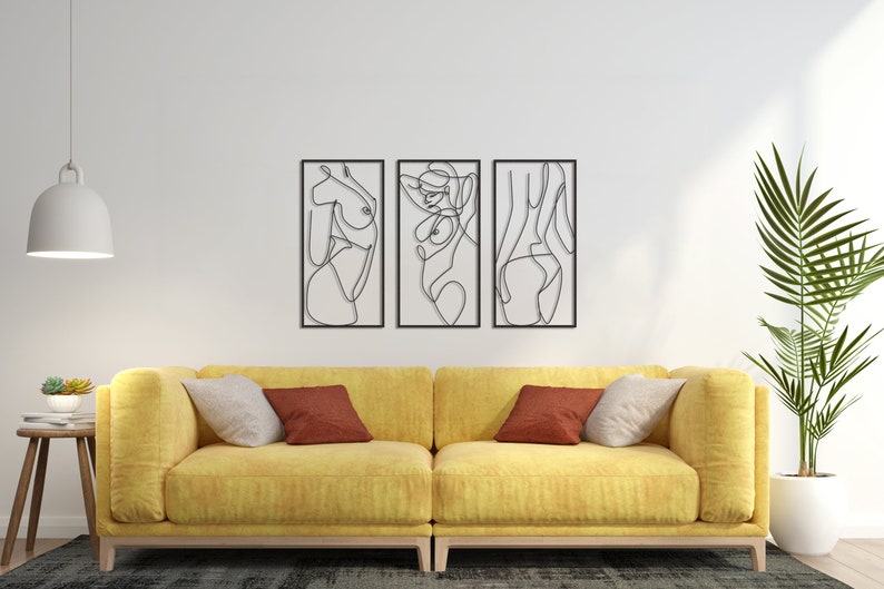 May include: A set of three rectangular wall art pieces featuring black continuous line drawings of human figures. Each piece is framed in a thin black border, showcasing abstract silhouettes of the body in a minimalist, single-line artistic style.