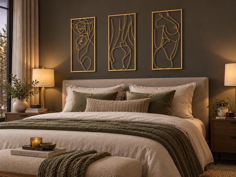 May include: A set of three rectangular gold-colored metal wall art pieces featuring continuous line drawings of human figures. Each piece is framed in a thin gold border and displays a unique abstract silhouette of a person in a minimalist style.