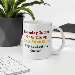May include: White ceramic mug with the text "Laundry Is The Only Thing That Should Be Separated By Color" in a colorful font.