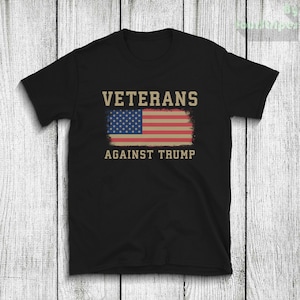 Könnte beinhalten: Schwarzes T-Shirt mit einer abgenutzten amerikanischen Flagge und dem Text "Veterans Against Trump" in Weiß.