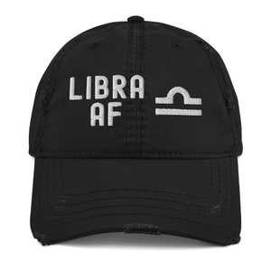 May include: Black distressed baseball cap with white embroidered text "LIBRA AF" and the Libra zodiac symbol.