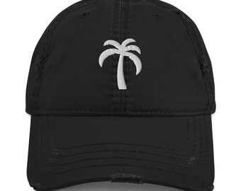 May include: A black distressed baseball cap with a white embroidered palm tree design.