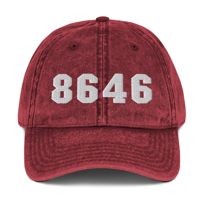 May include: A red vintage washed cotton baseball cap with white embroidered text that reads "8646".