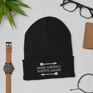 May include: Black beanie with white embroidery that reads "Make America Native Again" with two arrows pointing in opposite directions.