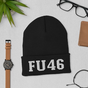 Puede incluir: Gorro negro con un "FU46" bordado en blanco en el puño.