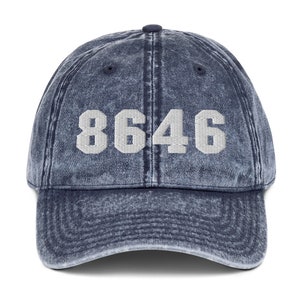 May include: A blue denim baseball cap with the number 8646 embroidered in white on the front.