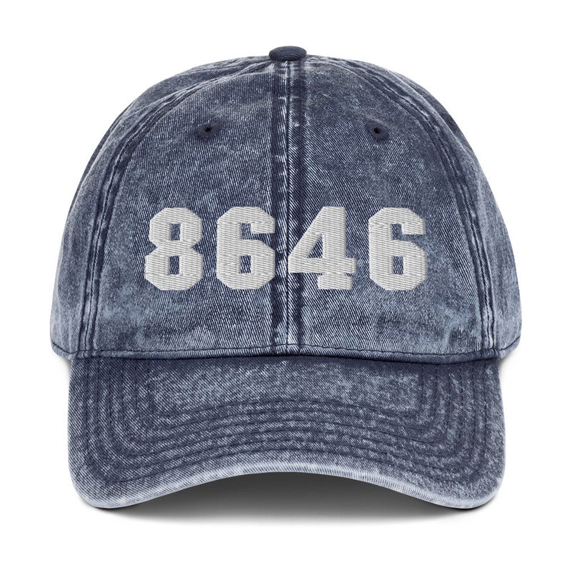 May include: A blue denim baseball cap with the number 8646 embroidered in white on the front.