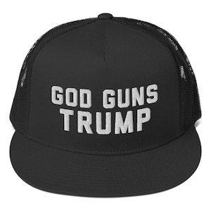 Puede incluir: Gorra de camionero negra con malla blanca en la parte posterior. La parte delantera de la gorra tiene el texto "GOD GUNS TRUMP" bordado en blanco.