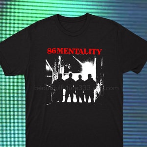 以下が含まれることがあります： 3人の人物がドアの入り口に立っている白いグラフィックがプリントされた黒いTシャツ。グラフィックの上に赤い文字で「86MENTALITY」とプリントされています。