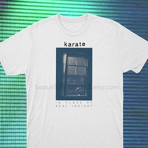 Puede incluir: Camiseta blanca con una foto en blanco y negro de una ventana con el texto "karate" encima de la foto y "IN PLACE OF REAL INSIGHT" debajo de la foto.