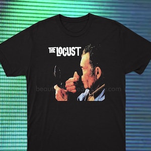 May include: Black t-shirt with a graphic of a man looking in a mirror. The text "THE LOCUST" is printed above the image.