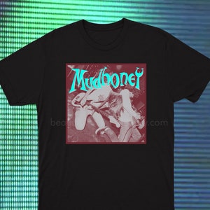 May include: Black t-shirt with a vintage-style image of a band called "Mudhoney". The image is in shades of pink and blue and features two people playing guitars.
