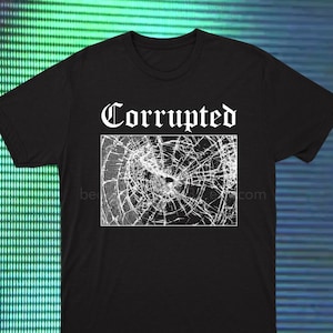 Puede incluir: Camiseta negra con la palabra "Corrupted" en fuente gótica sobre un gráfico blanco de vidrio roto. El gráfico está en un marco rectangular. La camiseta tiene cuello redondo.