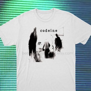 Puede incluir: Camiseta blanca con una imagen en blanco y negro de una banda llamada "Codeine" impresa en la parte delantera.