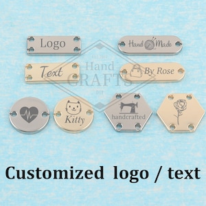 May include: A collection of metal tags in various shapes, including rectangles and circles. The tags feature engraved text and symbols such as "Logo", "Hand Made", a heart, a cat face, a sewing machine, and a rose. The text "Customized logo / text" is displayed below.