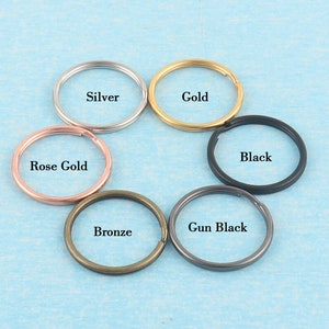 Könnte beinhalten: Sechs Schlüsselringe in verschiedenen Farben: Silber, Gold, Roségold, Schwarz, Schwarz matt und Bronze.