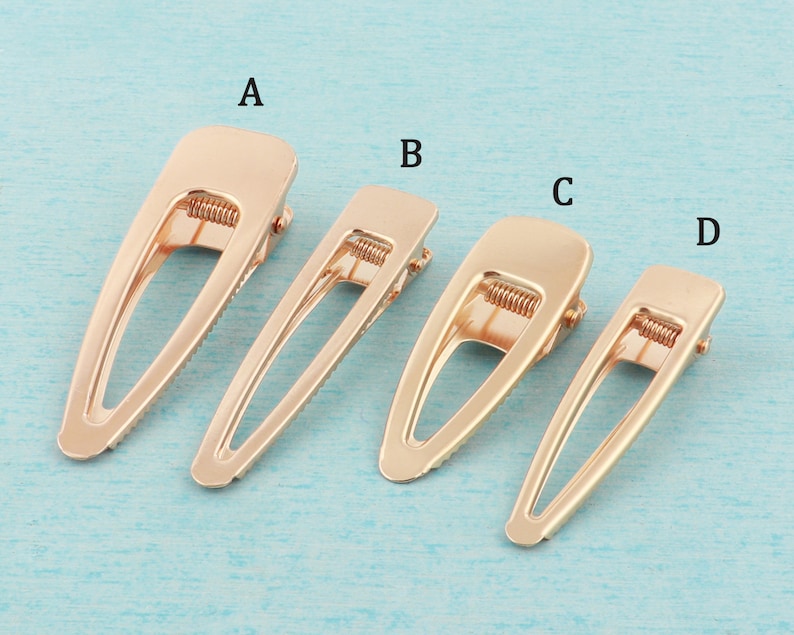 May include: Four gold metal hair clips of different sizes. The clips are labeled A, B, C, and D.