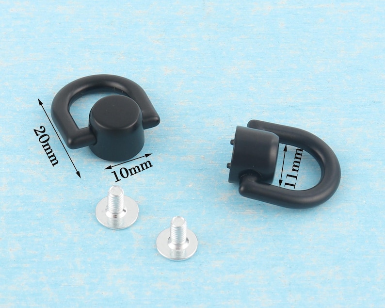 May include: Black metal D-ring hardware with silver screws. The D-rings are 20mm long and 10mm wide. The other D-ring is 11mm long. Ideal for bag making, leathercraft, and other DIY projects.