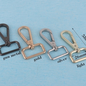 May include: Four metal swivel clasps in gun metal, gold, silver, and light gold. The clasps are 5.8 cm long and 2.6 cm wide.