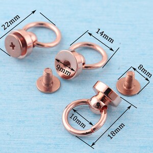 May include: Two rose gold metal ring and post hardware sets with screw-on posts. The larger set has a 1.4 inch diameter ring and a 0.9 inch diameter post. The smaller set has a 1 inch diameter ring and a 0.7 inch diameter post.