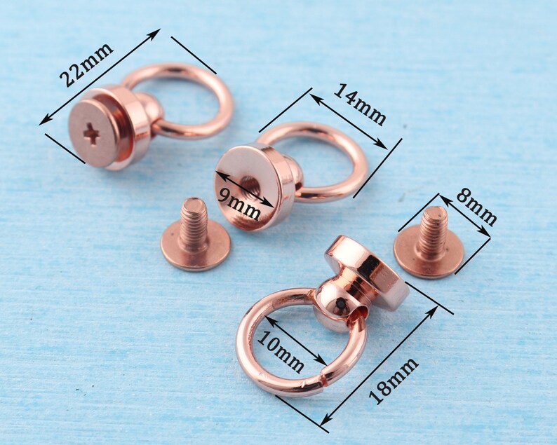 May include: Two rose gold metal ring and post hardware sets with screw-on posts. The larger set has a 1.4 inch diameter ring and a 0.9 inch diameter post. The smaller set has a 1 inch diameter ring and a 0.7 inch diameter post.