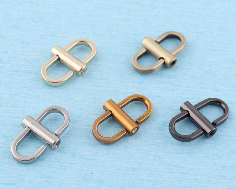 May include: Five metal D-ring clasps in different finishes: silver, gold, antique brass, and black. These clasps are ideal for attaching straps, chains, or other accessories to bags, purses, or other projects.