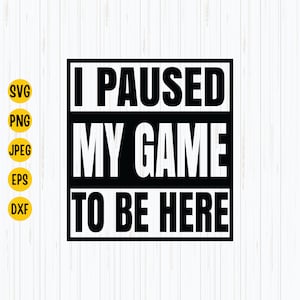 Può includere: Un design grafico in bianco e nero con il testo "I PAUSED MY GAME TO BE HERE" in grassetto, carattere sans-serif. Il design è ambientato su uno sfondo bianco con un motivo a venature del legno. Il lato sinistro ha il testo "SVG, PNG, JPEG, EPS, DXF" in un cerchio giallo.