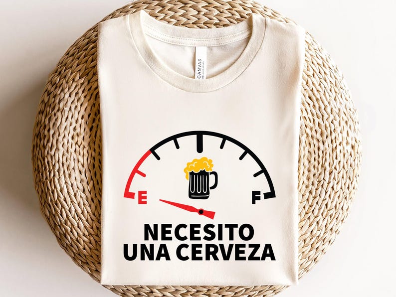 May include: A white t-shirt with a black and red fuel gauge graphic. The gauge is filled with a yellow beer mug and reads "Necesito una cerveza".