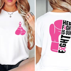 May include: White t-shirt with pink boxing gloves and a pink ribbon design. The back of the shirt features a pink boxing glove with the text "HER FIGHT IS OUR FIGHT".