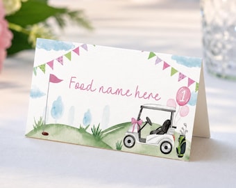 May include: A folded white card featuring a watercolor illustration of a golf course with green hills, a pink flag, a golf cart with a pink bow, a golf bag, and pink balloons. The text Food name here is printed in pink script on the front.