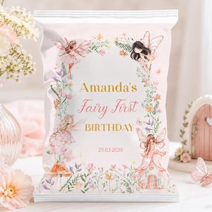May include: A rectangular snack bag with a light pink background featuring floral illustrations, fairy characters, and the text Amanda's Fairy First BIRTHDAY 25.03.202X. The design includes various wildflowers, butterflies, and small fairy figures.