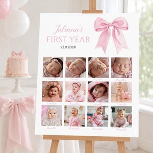 May include: A white milestone board titled Juliana's FIRST YEAR with the date 25.11.202X, featuring a large pink bow graphic and twelve square photographs documenting a baby's growth from one to twelve months, displayed on a wooden easel.