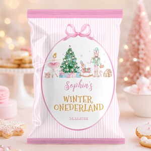 May include: A pink and white striped snack bag featuring a central oval graphic with a ballerina, a Christmas tree, a rocking horse, and a nutcracker. The text reads Sophia's WINTER ONEDERLAND and 16.12.202X, topped with a pink bow illustration.