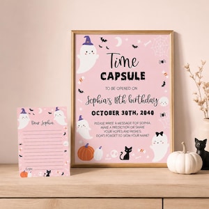 May include: A pink Time Capsule sign and matching stationery card featuring white ghosts in purple hats, black cats, orange pumpkins, bats, and spiderwebs. The text reads Time Capsule to be opened on Sophia's 18th birthday October 30th, 2040.