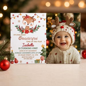 May include: A rectangular birthday invitation card featuring a cartoon deer, Christmas trees, and gifts. The text reads: IT'S THE MOST Onederful TIME OF THE YEAR Isabella IS TURNING ONE! JOIN US TO CELEBRATE SUNDAY | DECEMBER 12TH | AT 2PM 323 MAIN STREET, CA. 1456 RSVP TO ERIN AT 677.855.969.