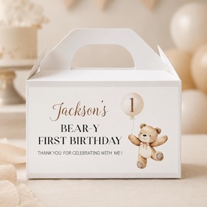 May include: A white cardboard gable box featuring a printed design with the text Jackson's BEAR-Y FIRST BIRTHDAY THANK YOU FOR CELEBRATING WITH ME! and an illustration of a brown teddy bear holding a beige balloon with the number 1 inside.