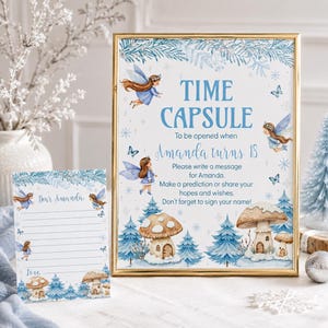May include: A gold-framed sign and matching card featuring blue fairy illustrations, snowy pine trees, and mushroom houses. The sign reads: TIME CAPSULE To be opened when Amanda turns 18. Please write a message for Amanda. Make a prediction or share your hopes and wishes. Don't forget to sign your name!