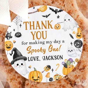 May include: A star-shaped cookie in a clear cellophane bag, tied with a white ribbon. A round sticker on the bag reads "THANK YOU for making my day a Spooky One! LOVE, JACKSON" with Halloween-themed illustrations.