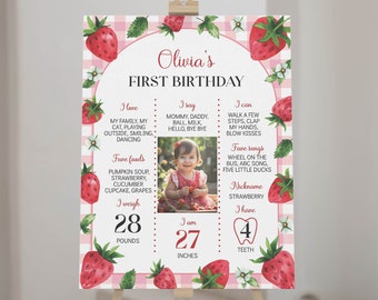 Op de afbeelding: Een roze en witte gingham achtergrond met een aardbeien thema. Een foto van een babymeisje staat in het midden van de poster. De poster vermeldt de leeftijd, het gewicht, de lengte, favoriete voedingsmiddelen, liedjes en activiteiten van de baby. De tekst luidt "Olivia's First Birthday".