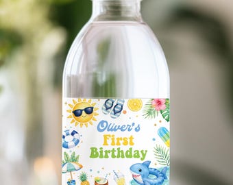 May include: A clear plastic water bottle with a white cap and a custom label featuring a summer theme. The label displays the text Oliver's First Birthday, a smiling sun with sunglasses, flip-flops, a shark, a pineapple, and tropical foliage.