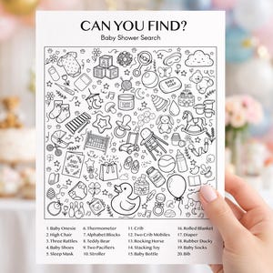 May include: A black and white baby shower search game with the text "CAN YOU FIND? Baby Shower Search". The game features illustrations of baby items like a onesie, crib, and teddy bear. A hand is holding the game.