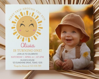 May include: A yellow sun with a smiling face and pink cheeks, surrounded by rays of light. The text "First Trip Around The Sun" is written in a circle around the sun. Below the sun, the text "Olivia is turning one!" is written in pink. The text "Join us to celebrate! Saturday | April 15 | At 2PM Olivia's House 123 Sunshine Drive, Texas, 1235 Rsvp to Anna at 123.456.789" is written below the text "Olivia is turning one!" A photo of a baby wearing a brown hat is in the background.