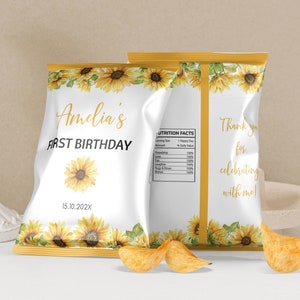 May include: A white chip bag with a sunflower design and the text "Amelia's First Birthday 15.10.202X". The back of the bag has the text "Thank you for celebrating with me!" and a nutrition facts label.
