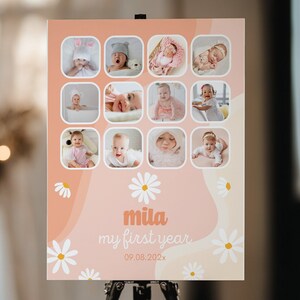 May include: A personalized baby milestone poster with a peach and white daisy design. The poster features twelve baby photos, the name "mila", and the text "my first year" with a date. The words "Goober Studio Prints" are at the top.
