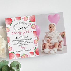 May include: A rectangular birthday invitation card featuring a watercolor strawberry border and text that reads JOIN US TO CELEBRATE OLIVIA'S berry first BIRTHDAY SATURDAY AUGUST 12TH AT 2 PM OLIVIA'S HOUSE 123 MAIN STREET LOS ANGELES CALIFORNIA 1235 RSVP TO EMILY AT 677.855.969.