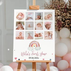 May include: A rectangular sign on a wooden easel featuring a grid of twelve baby photographs, a central watercolour rainbow illustration, and the text "Mila's First Year" followed by the date "09.06.202x" with small pink heart and dot accents.