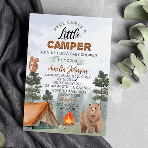 Op de afbeelding: Een rechthoekige uitnodigingskaart voor een babyshower met een aquarel bossc&egrave;ne, een bruine beer, een eekhoorn, een tent en een kampvuur. De tekst luidt: HERE COMES A LITTLE CAMPER, JOIN US FOR A BABY SHOWER HONORING Amelia Johnson, SUNDAY, MARCH 12, 202X.